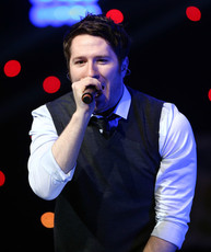 Picture of Adam Young singing at a concert